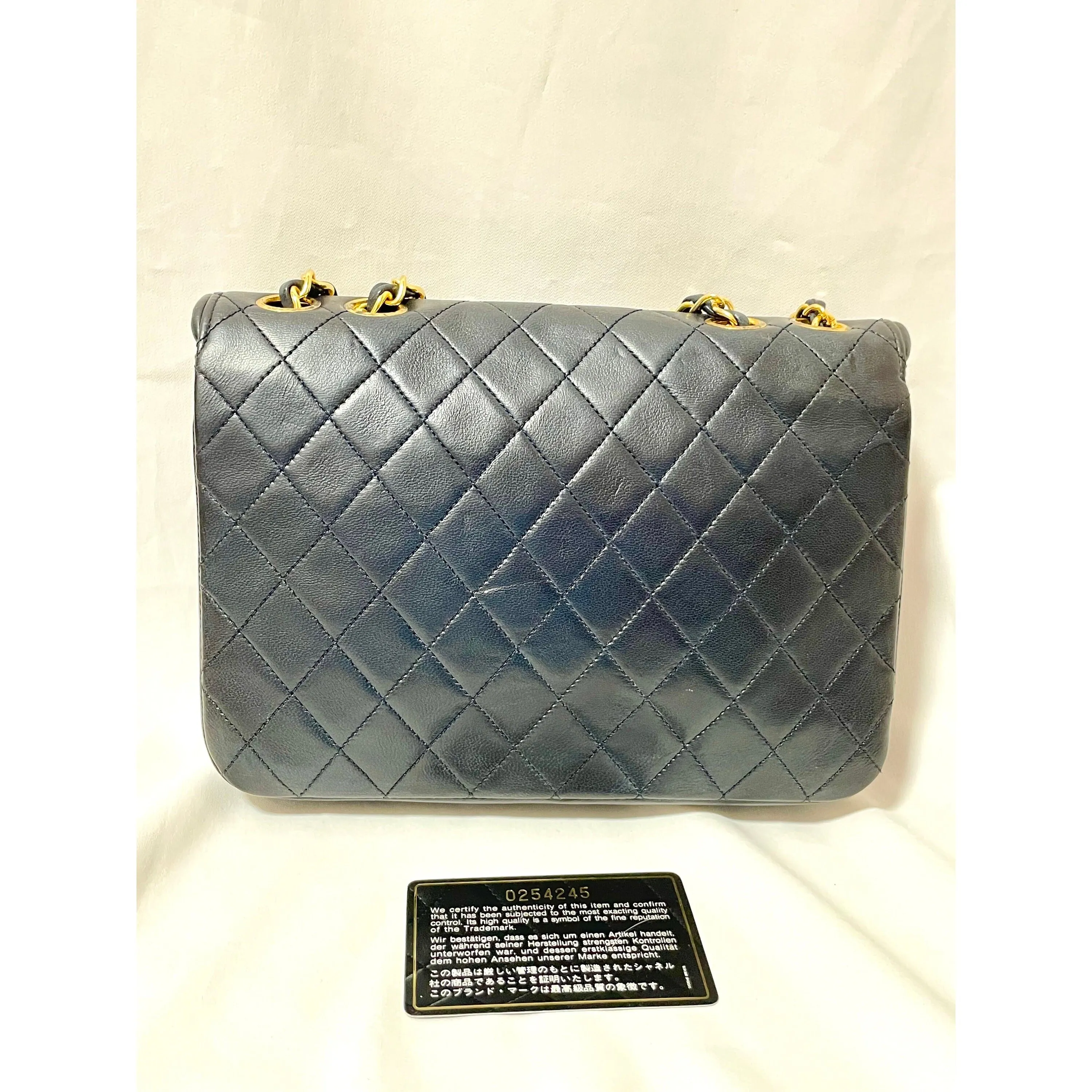 80's vintage Chanel dark navy lambskin 2.55 classic shoulder bag with gold chain and turn lock cc closure. Unique oval red edges. 051205ac4