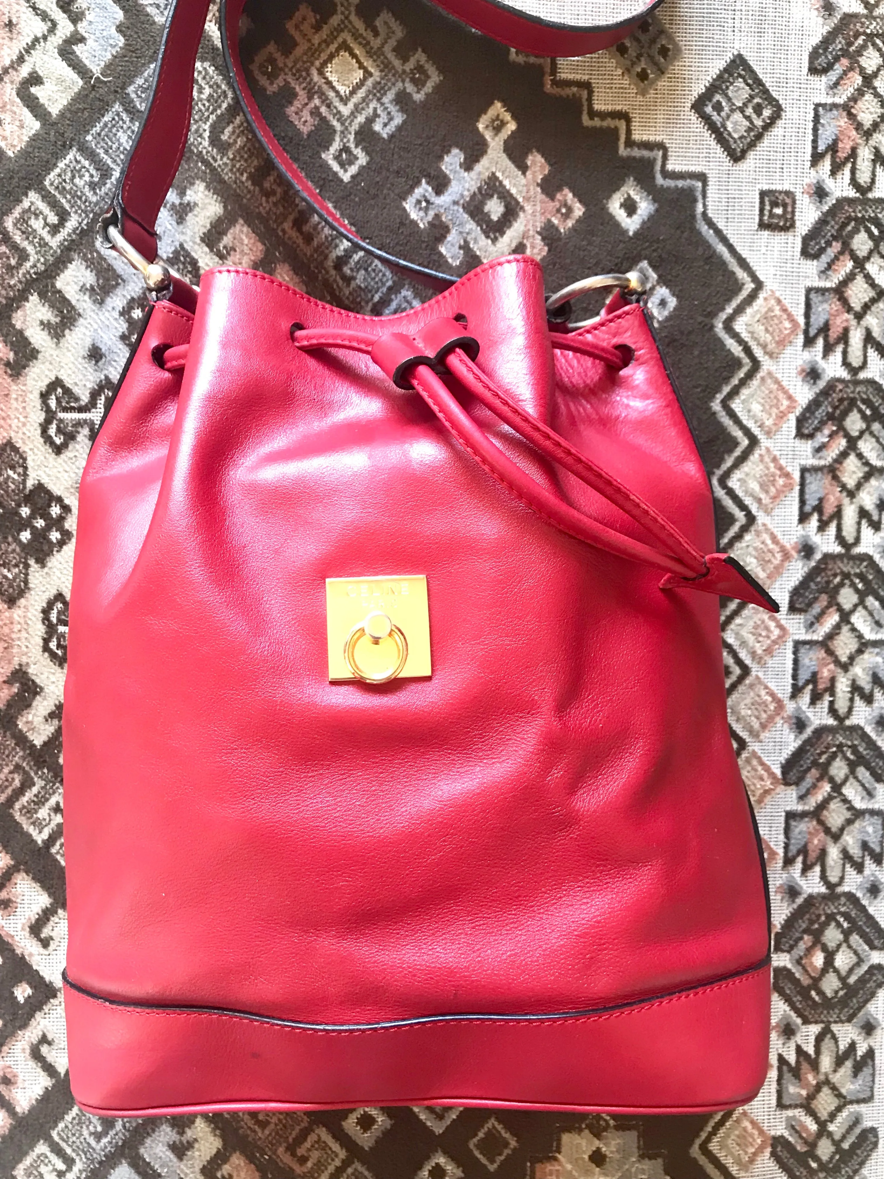 Vintage Celine red leather hobo bucket shoulder bag with a golden square logo motif and matching pouch. Classic drawstrings purse.