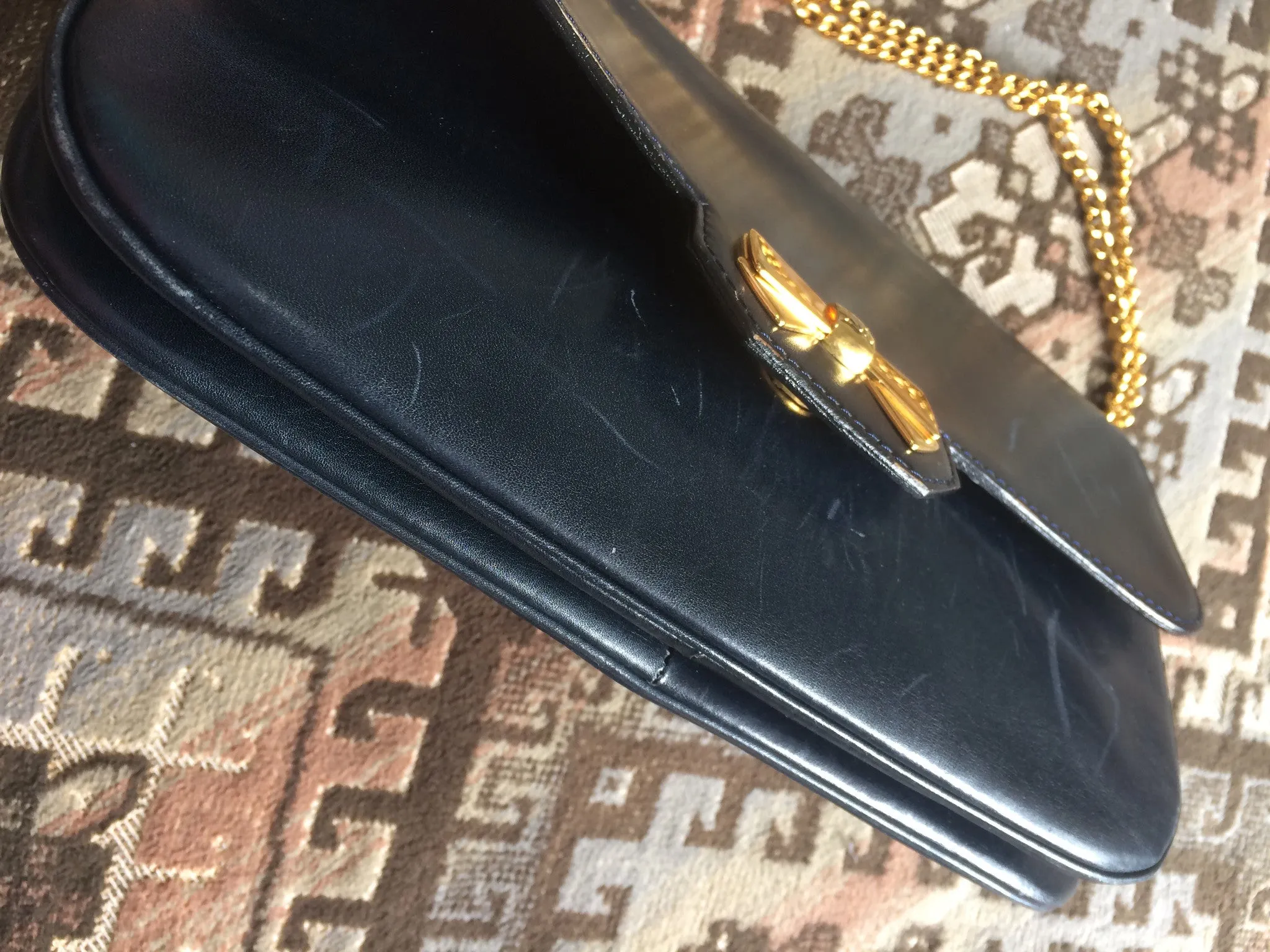 Vintage Nina Ricci navy leather clutch chain shoulder bag, classic purse with golden ribbon logo motif. Mod and chic daily purse.
