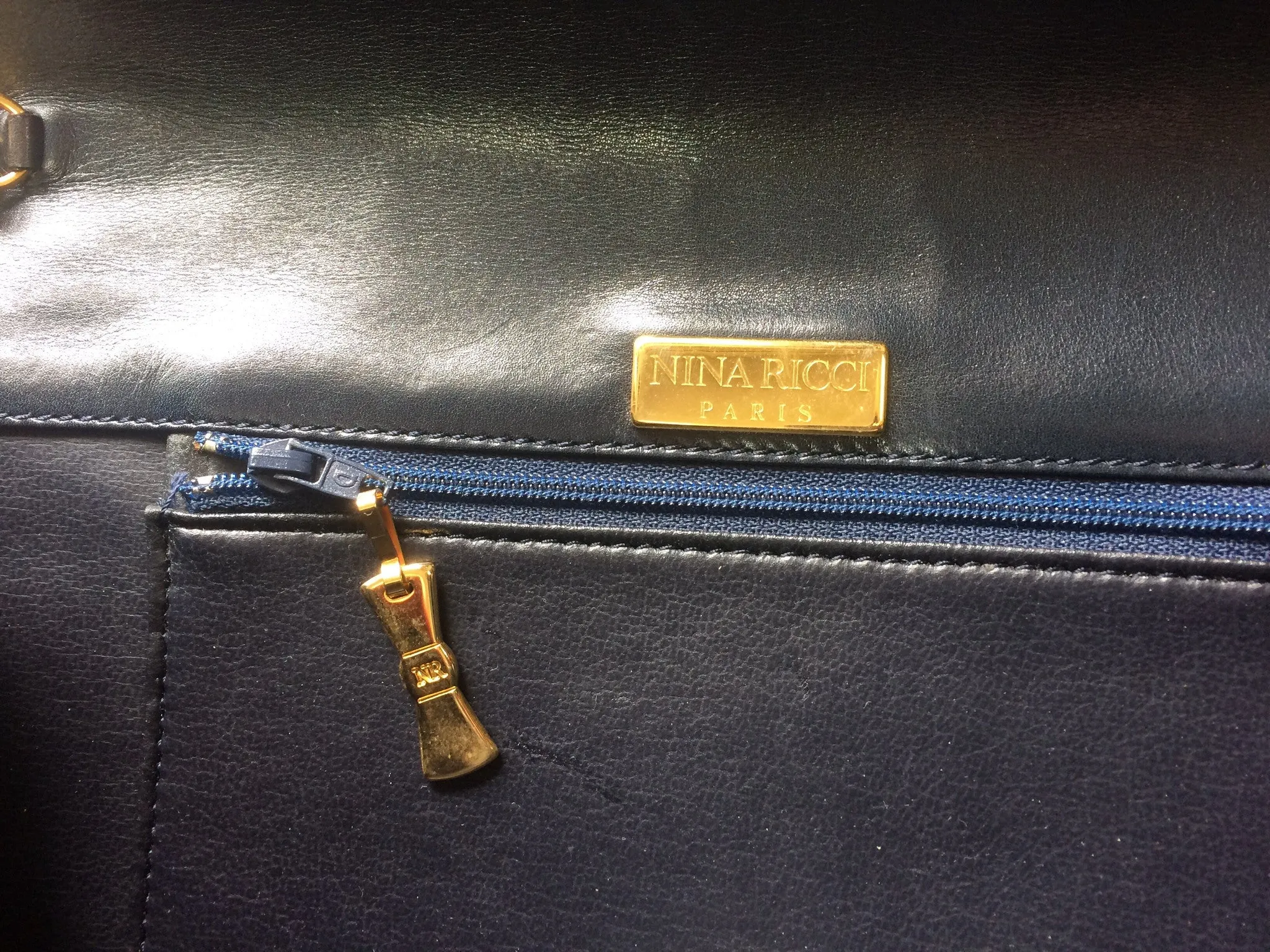 Vintage Nina Ricci navy leather clutch chain shoulder bag, classic purse with golden ribbon logo motif. Mod and chic daily purse.