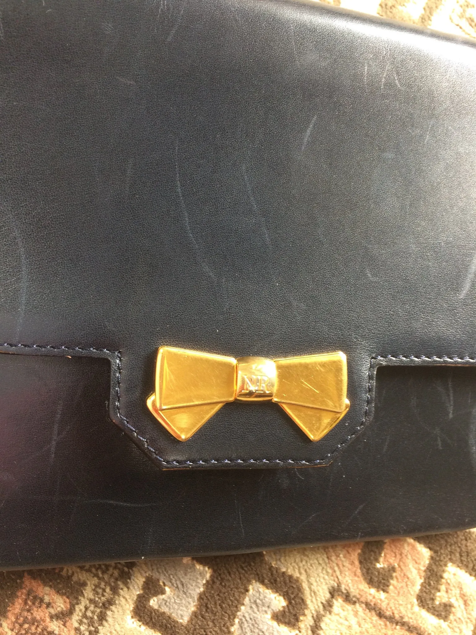 Vintage Nina Ricci navy leather clutch chain shoulder bag, classic purse with golden ribbon logo motif. Mod and chic daily purse.