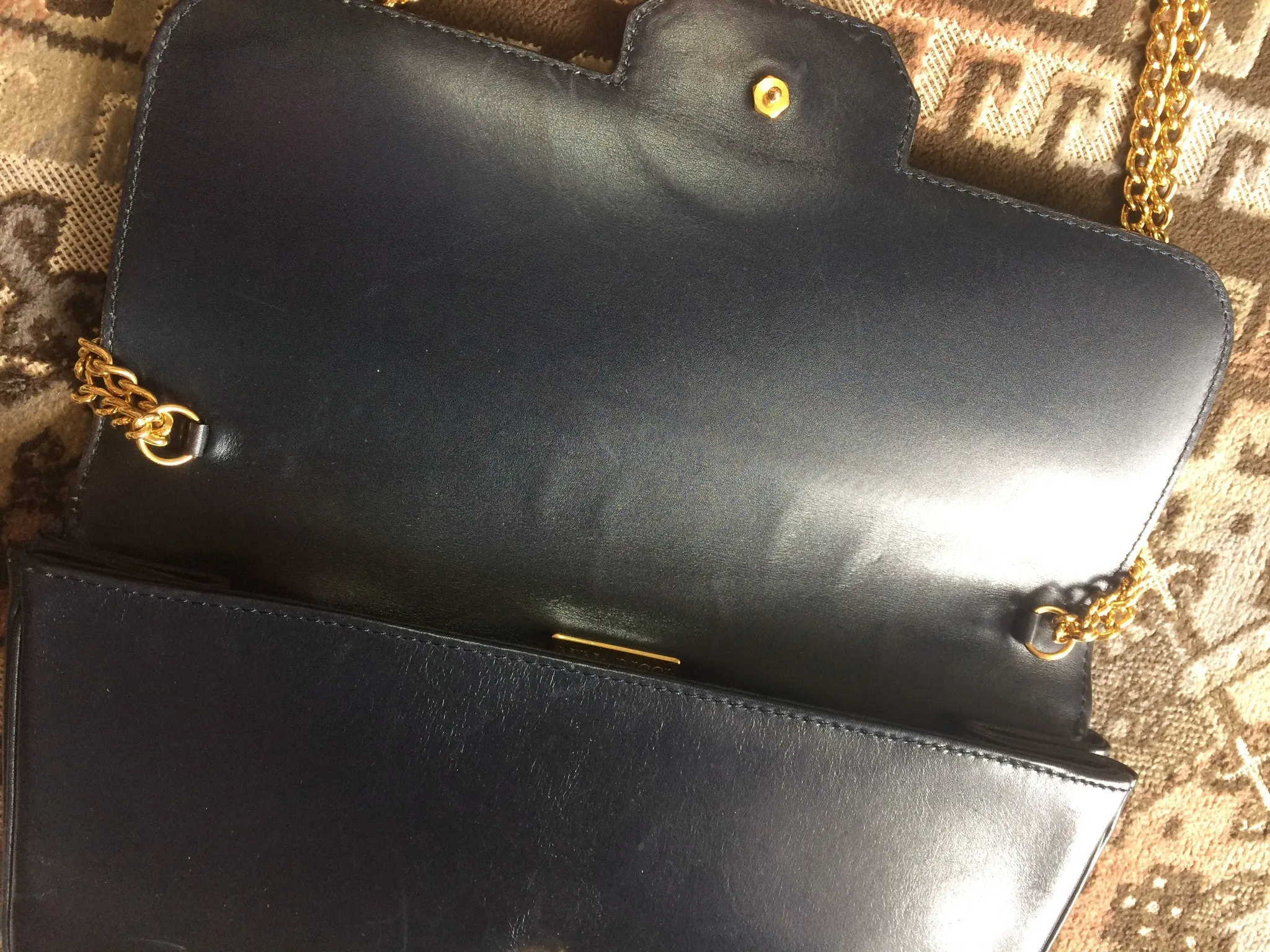 Vintage Nina Ricci navy leather clutch chain shoulder bag, classic purse with golden ribbon logo motif. Mod and chic daily purse.