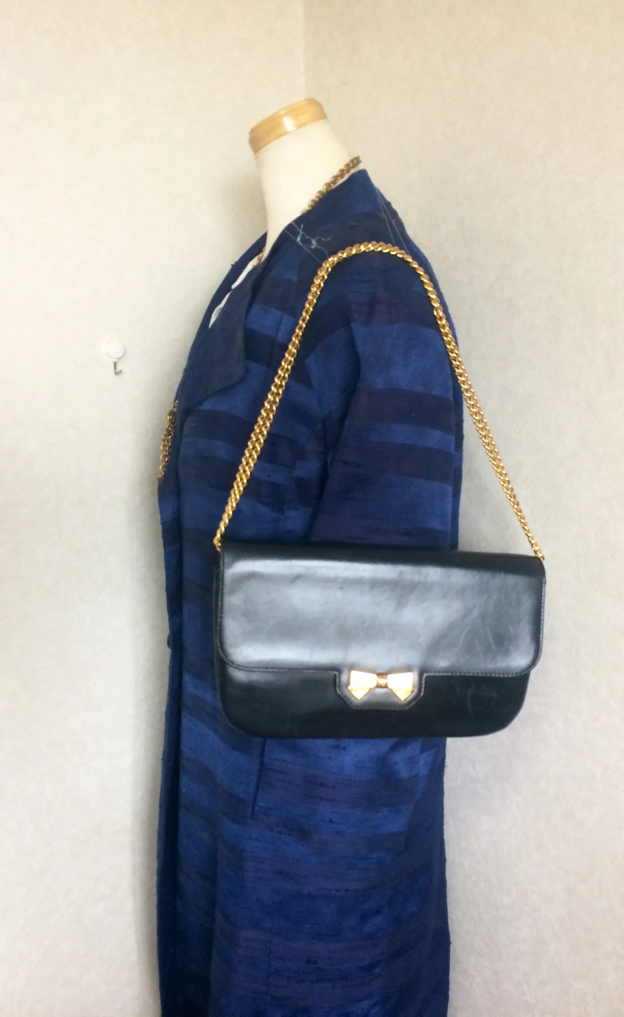 Vintage Nina Ricci navy leather clutch chain shoulder bag, classic purse with golden ribbon logo motif. Mod and chic daily purse.