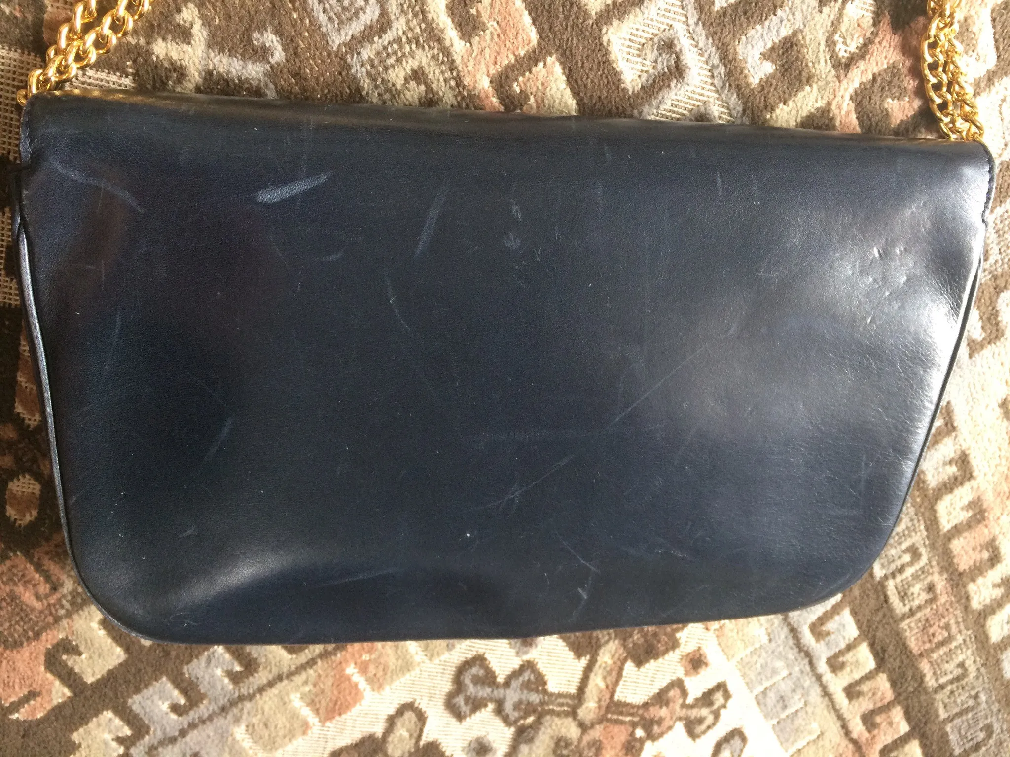 Vintage Nina Ricci navy leather clutch chain shoulder bag, classic purse with golden ribbon logo motif. Mod and chic daily purse.