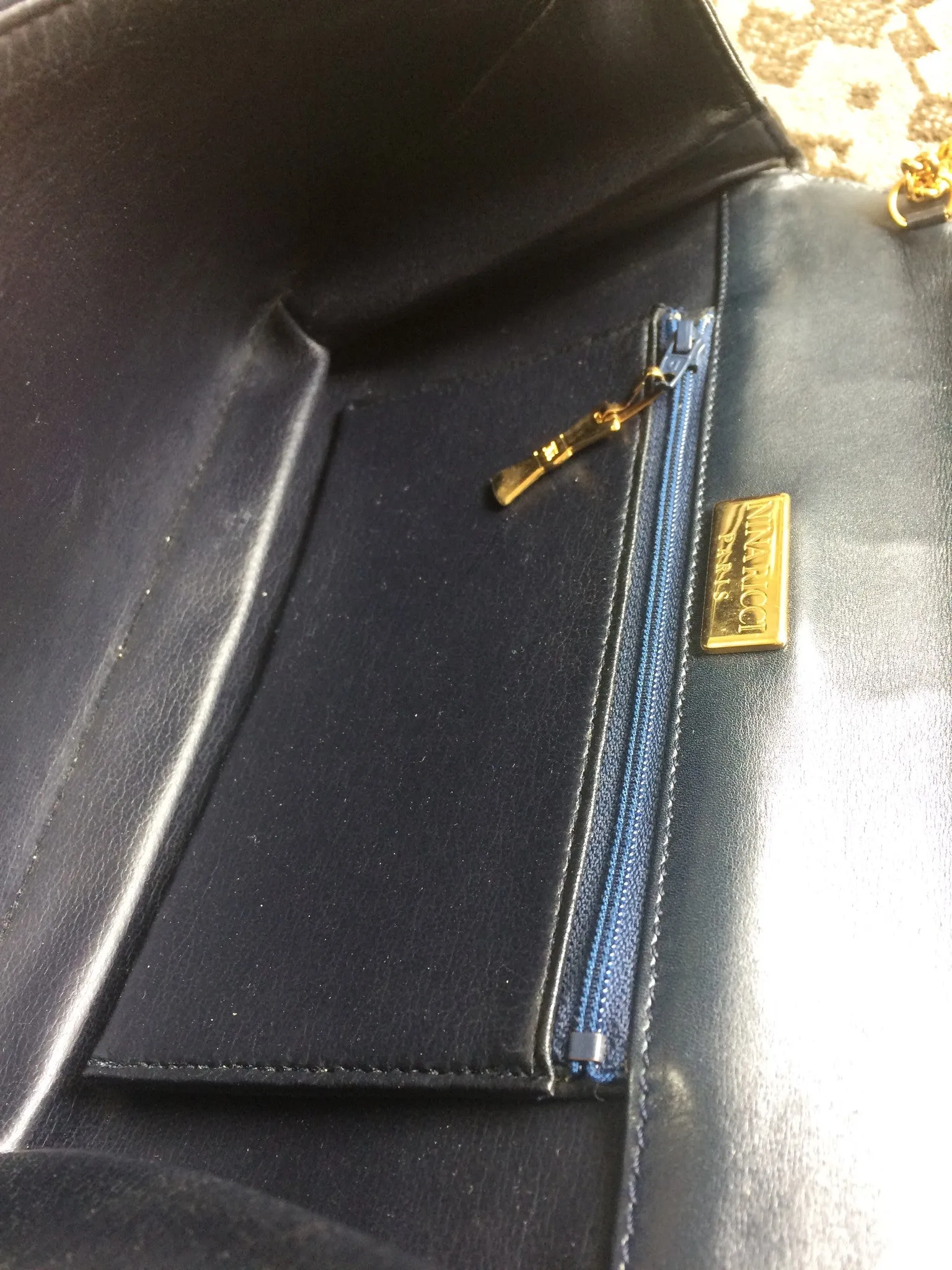 Vintage Nina Ricci navy leather clutch chain shoulder bag, classic purse with golden ribbon logo motif. Mod and chic daily purse.